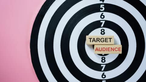 conceptual image with the words target audience inside the bullseye of a dart board